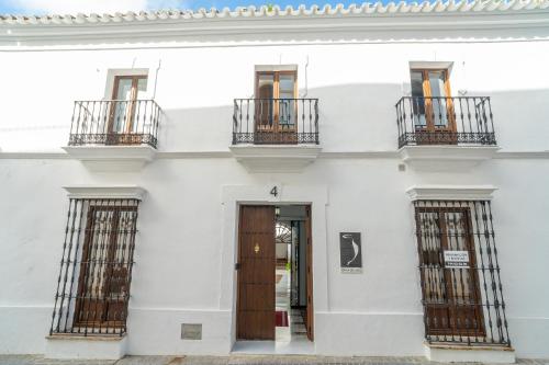 a white building with two balconies and a door at CASA DE LA SEÑORA in Palma del Río