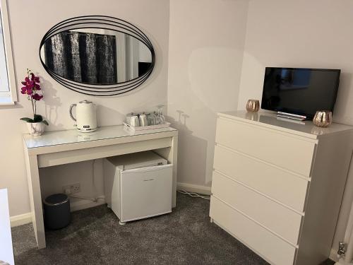 białe biurko z telewizorem i lustrem w obiekcie The Cosy Corner w mieście Kent