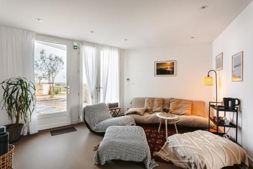a living room with a couch and a table at Les Pins, studio vue mer in Rivedoux-Plage