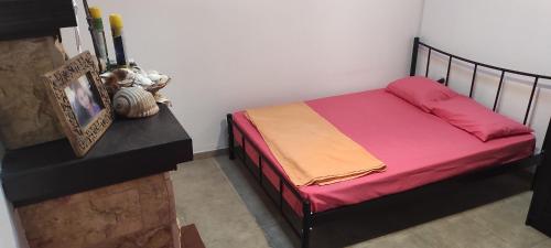 ein kleines Schlafzimmer mit einem Bett mit bunter Bettwäsche in der Unterkunft Detached House in Sykia in Sykia