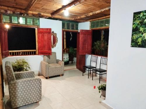 ein Wohnzimmer mit Stühlen und einem großen Bildschirm in der Unterkunft CARRIQUI in Calarcá