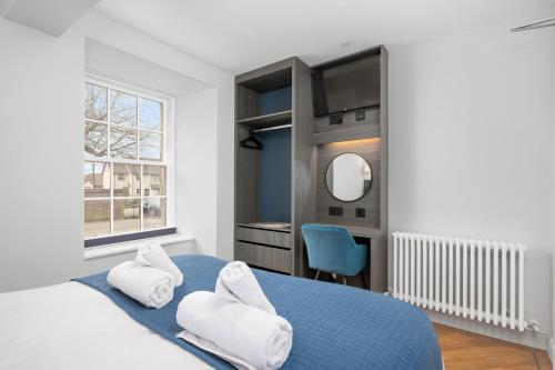 - une chambre avec un lit bleu et un miroir dans l'établissement 314 Reids Corner - by StayDunfermline, à Dunfermline
