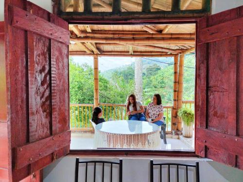 eine Gruppe von drei Frauen, die um einen Tisch auf einer Veranda sitzen in der Unterkunft CARRIQUI in Calarcá