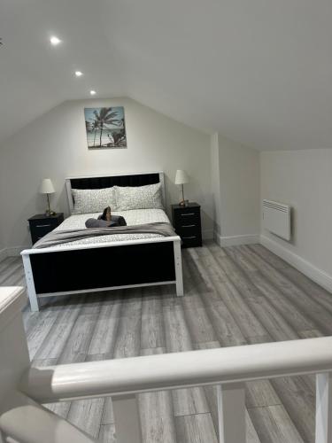 a white bedroom with a bed and two night stands at Guest&rest Ealing 6 in Ealing