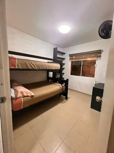 a room with two bunk beds and a window at Depa con alberca en privada in Cancún