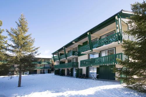 a building with green balconies in the snow at Résidence Pierre & Vacances Pyrenees 2000 Le Séquoia in Bolquere Pyrenees 2000