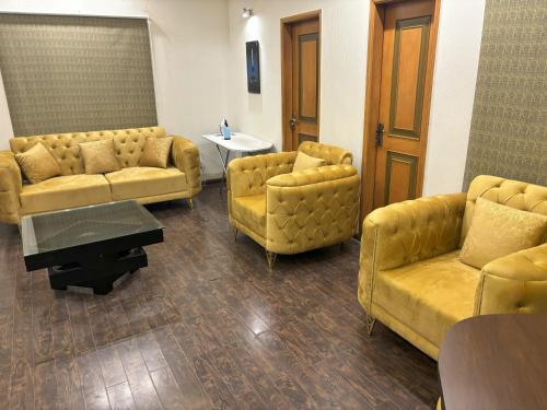 a waiting room with yellow couches and a table at 3-Bedrooms Luxury Apartment in Lahore