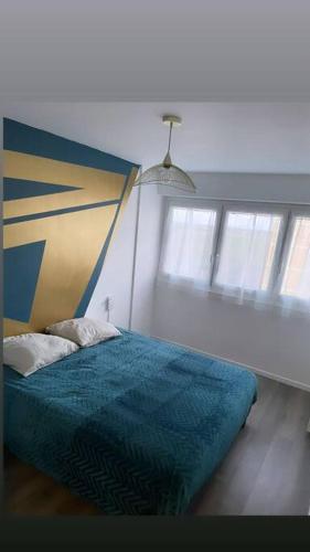 une chambre avec un lit avec une couette bleue dans l'établissement Hibiscus : T2 Melun, à Melun