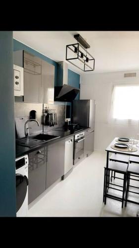 une cuisine avec un évier et une table à l'intérieur dans l'établissement Hibiscus : T2 Melun, à Melun