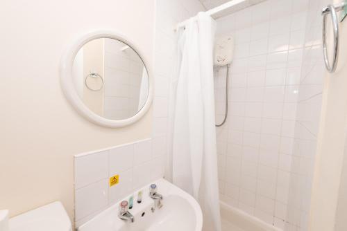 uma casa de banho branca com um lavatório e um espelho em Superior En-suite Apartment 6 em Plymouth
