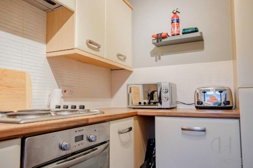 a kitchen with a counter top with a stove and a toaster at Blackthorn in Bury Saint Edmunds