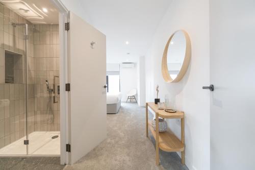 a bathroom with a shower and a mirror at Urban Chic - Marine in London