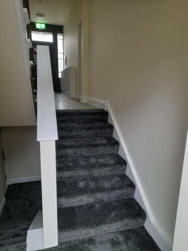a staircase in a building with a white stair case at Kirkcudbright Holiday Apartments - Apartment A in Kirkcudbright