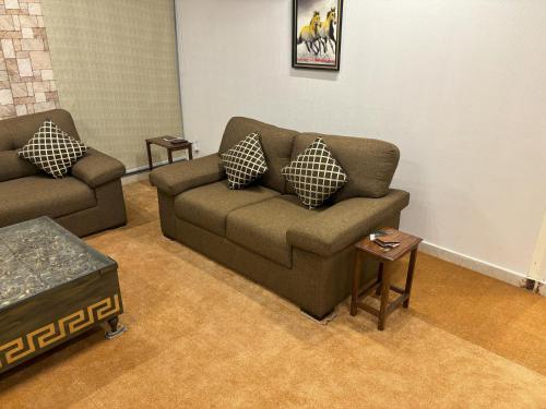 a living room with two couches and a table at 3-Bedrooms Luxury Apartment in Lahore