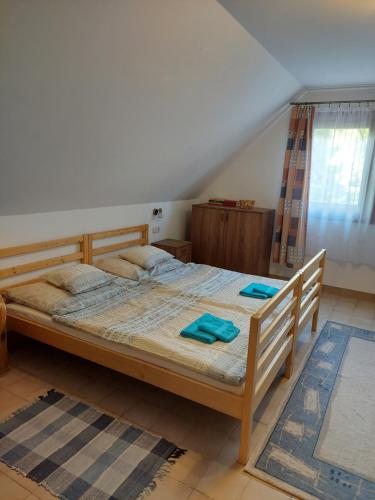 1 dormitorio con 1 cama grande y toallas azules. en Kis sori Vendégház Császártöltés, en Császártöltés