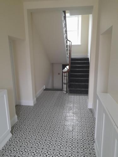 an empty hallway with a staircase and a stair case at Kirkcudbright Holiday Apartments - Apartment A in Kirkcudbright