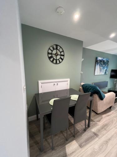 a living room with a table and a clock on the wall at Mary McGill’s in Ballycastle