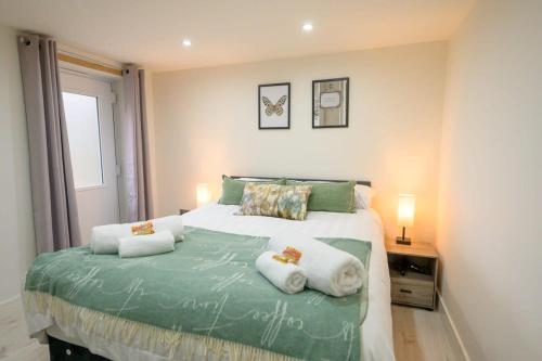 una camera con un letto con due cuscini sopra di The Den by StayStaycations a Rugeley