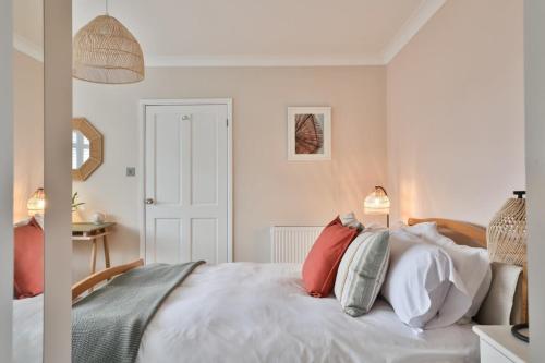 Un dormitorio con una cama blanca con almohadas. en Cloudbreak Braunton North Devon en Braunton