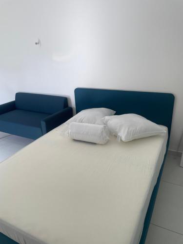 1 cama con 2 almohadas y silla azul en Studio indépendant accolé/villa, en Aviñón
