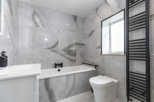 a bathroom with a tub and a toilet and a sink at H C Property - Doublegait in Barnard Castle
