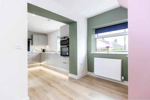 a kitchen with white cabinets and a window at H C Property - Doublegait in Barnard Castle