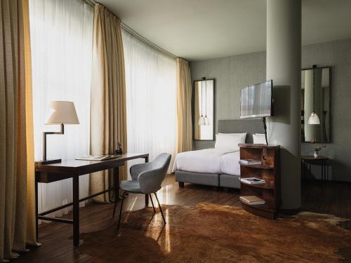 ein Hotelzimmer mit einem Bett, einem Schreibtisch und einem Computer in der Unterkunft ABION Villa Suites in Berlin