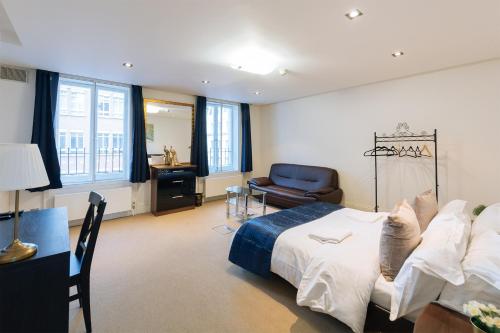 Curzon Residences في لندن: غرفة نوم بسرير وكرسي ومكتب