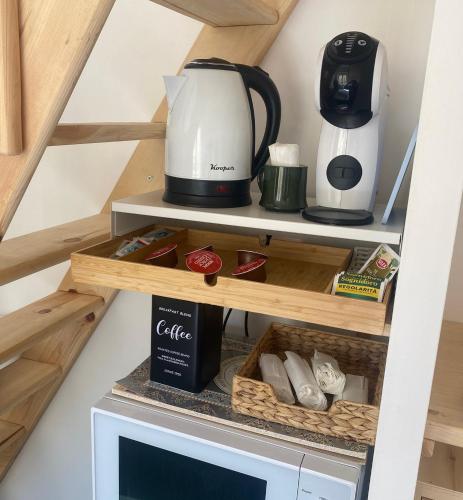 a coffeemaker and a coffee maker on a shelf at Nido sul mare! in Torvaianica