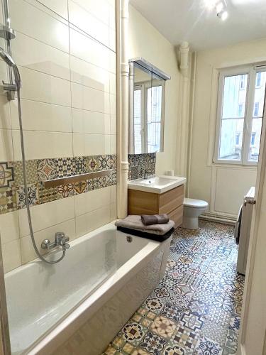 une salle de bain avec une baignoire, un lavabo et des toilettes dans l'établissement L' Appartement Richard-Lenoir, à Paris