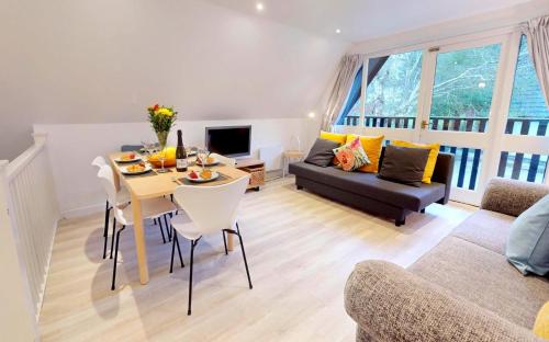 a living room with a table and a couch at St Ives Bluebell Cottage in St Ives