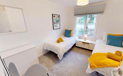 een slaapkamer met 2 bedden en een raam bij St Ives Bluebell Cottage in St Ives