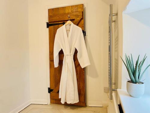 a robe hanging on a door in a bathroom at The Old Shop Broadway in Stanton