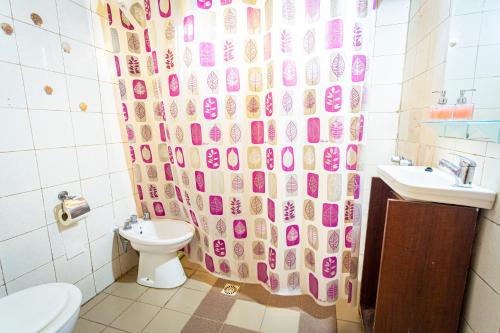 La salle de bains est pourvue d'un rideau de douche, de toilettes et d'un lavabo. dans l'établissement Casa de Campo La Lila, à Pocito