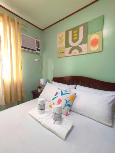um quarto com uma cama branca e toalhas em Palawan Paradise Condotel 2B em Puerto Princesa