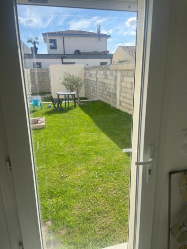 - une porte ouverte sur une cour avec une table de pique-nique dans l'établissement Studio indépendant accolé/villa, à Avignon