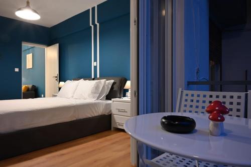 Dormitorio azul con cama y mesa en Modern Two Bedroom Apartment At Koukaki, en Atenas