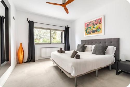 a bedroom with a large white bed and a window at Villa La Roca Madrid in Guadarrama