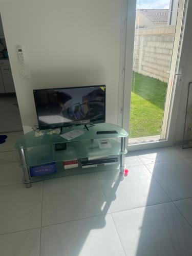 TV de pantalla plana en la parte superior de un armario de cristal en Studio indépendant accolé/villa, en Aviñón