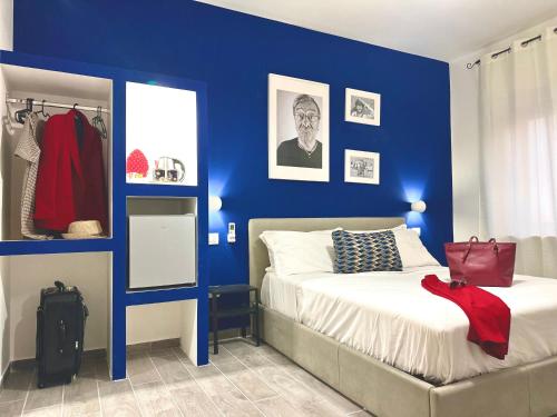 een slaapkamer met blauwe muren en een bed bij Room Center Sorrento Baby in Sorrento