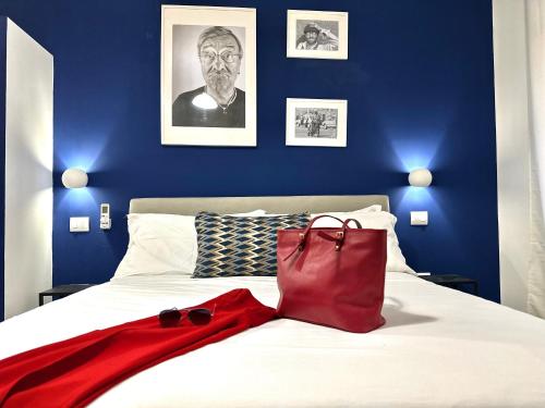 ein blaues Schlafzimmer mit einem Bett mit einer roten Tasche darauf in der Unterkunft Room Center Sorrento Baby in Sorrent