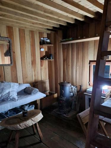 Cette chambre comprend un lit et une cuisinière. dans l'établissement Cabane sur Pilotis - Les Demoiselles, à Saint-Didier-sur-Arroux