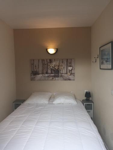 um quarto com uma grande cama branca em Corrèze rive Dordogne em Argentat