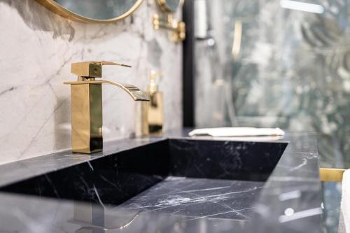 a bathroom sink with a gold faucet on a counter at Maison 31 -Luxury Apartments in Santa Marinella
