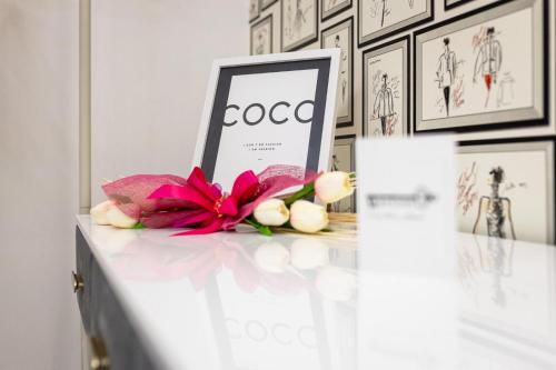 a table with a flower and a sign on it at Maison 31 -Luxury Apartments in Santa Marinella