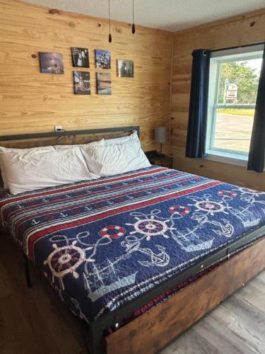 Un dormitorio con una cama con una manta. en Good Times Motel and Marina, en Steinhatchee
