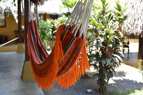 a hammock with orange fringe hanging in a garden at Hotel Las Hamacas in Santa Catalina