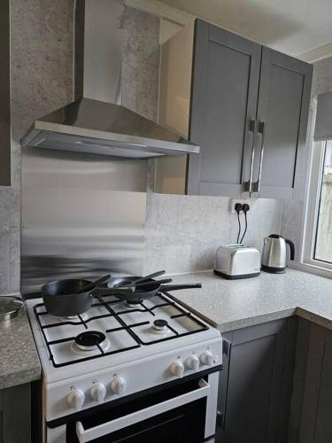 a kitchen with a stove top oven in a kitchen at Airport,NEC,JLR,Bham. Entire house 5 beds. in Kingshurst