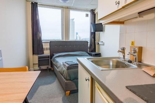 uma cozinha com um lavatório e uma cama num quarto em Standard En-suite Apartment 2 em Plymouth