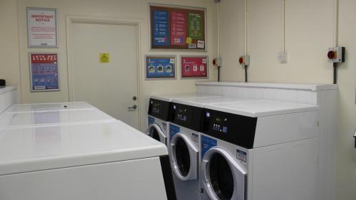 uma lavandaria com duas máquinas de lavar roupa e um balcão em Standard En-suite Apartment 2 em Plymouth